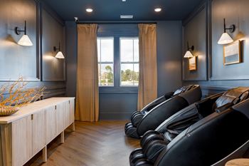 A room with black chairs and a wooden cabinet.